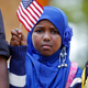 Ilhan Issa, a Somali-American girl from Minneapolis, waves an American flag.